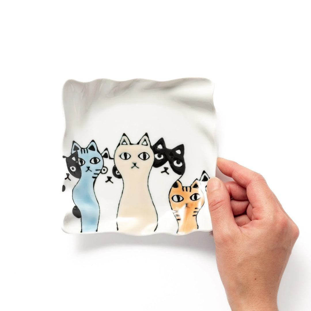 Wavy white dessert plate featuring colorful cats in black, orange, and blue, adding a playful charm to your table.
