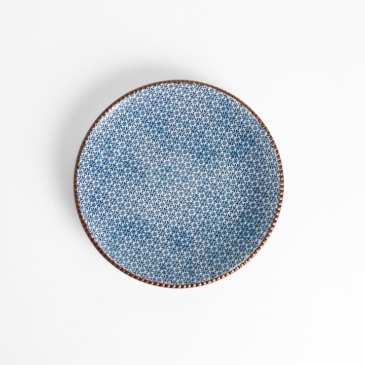 Ceramic plate with intricate blue floral design and bold circular motif framed by copper textured rim.