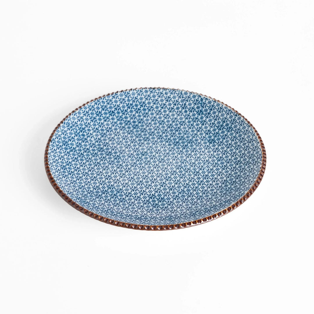 Ceramic plate with intricate blue floral design and bold circular motif framed by copper textured rim.