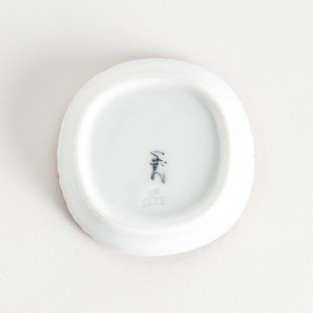 A round plate featuring a blue dotted geometric pattern with a textured brown rim.