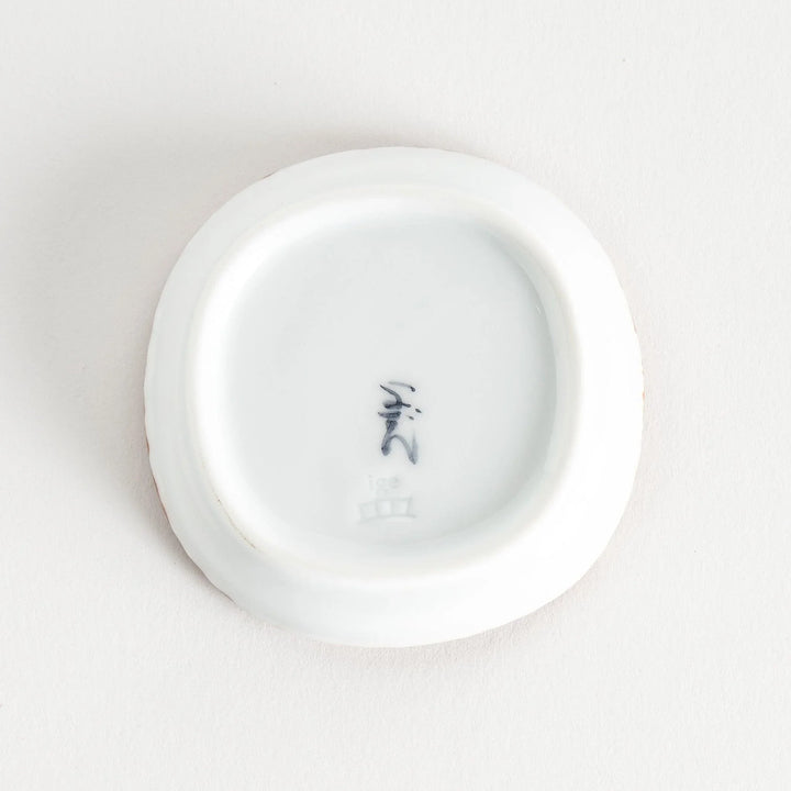 A round plate featuring a blue dotted geometric pattern with a textured brown rim.