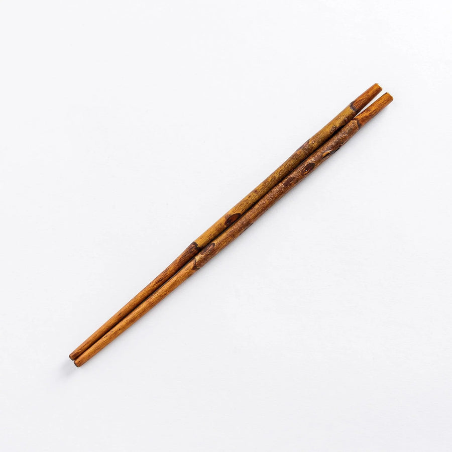 Pair of Dark Plum Branch Chopsticks on a plain background, highlighting the rustic wood grain and subtle color variations.