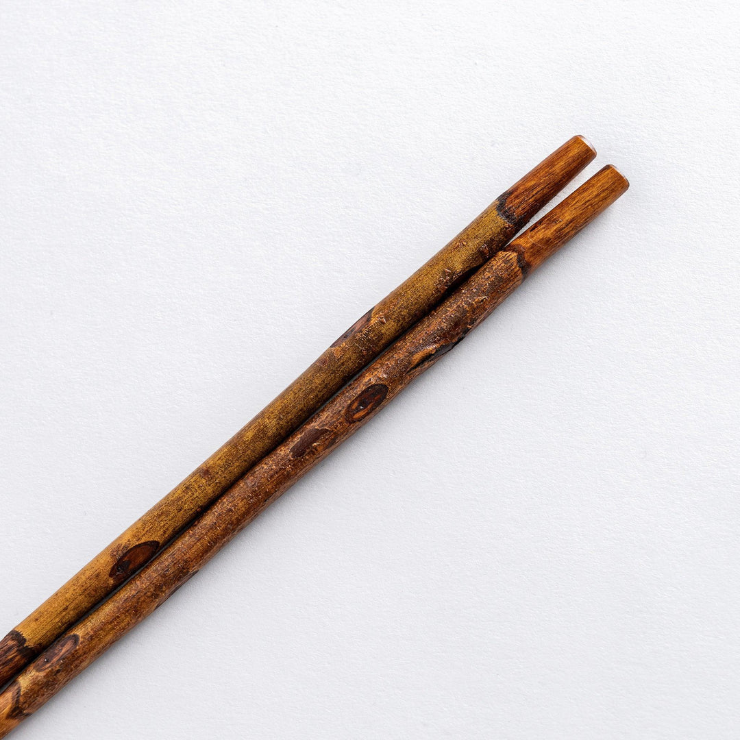 Close-up view of the tips of Dark Plum Branch Chopsticks, showcasing the natural, unrefined wood finish.