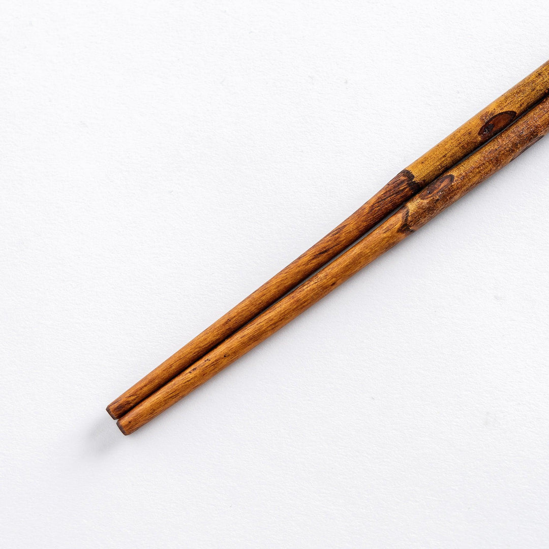 Dark Plum Branch Chopsticks in packaging, showing natural wood texture and intricate grain details.