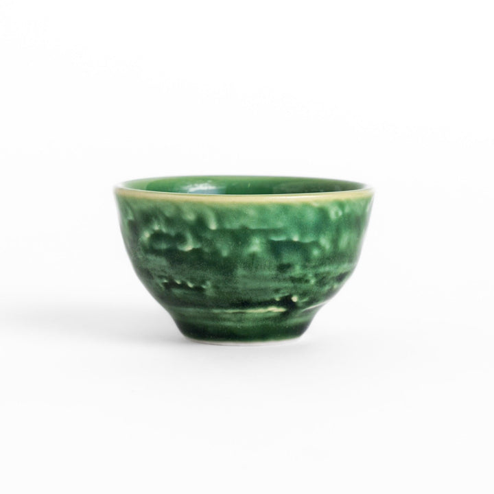 Deep green ceramic sake cup with glossy texture and round shape, perfect for enjoying traditional Japanese sake.