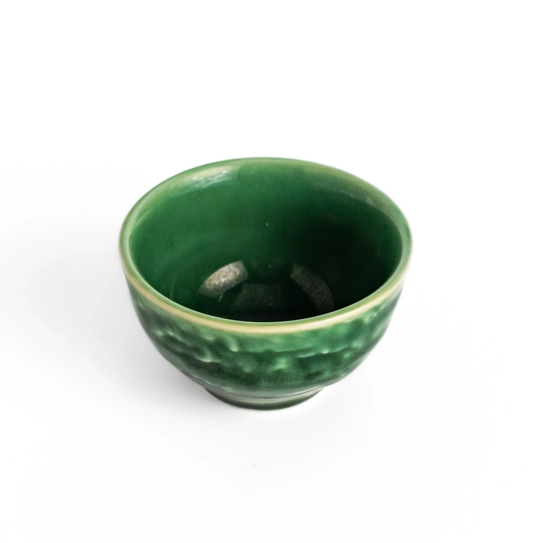 Deep green ceramic sake cup with glossy texture and round shape, perfect for enjoying traditional Japanese sake.