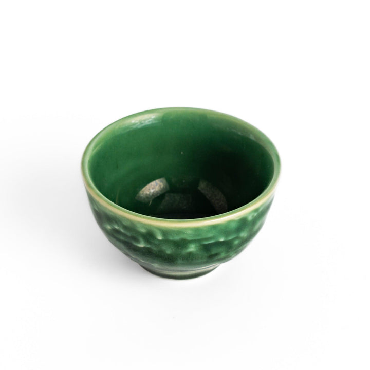 Deep green ceramic sake cup with glossy texture and round shape, perfect for enjoying traditional Japanese sake.