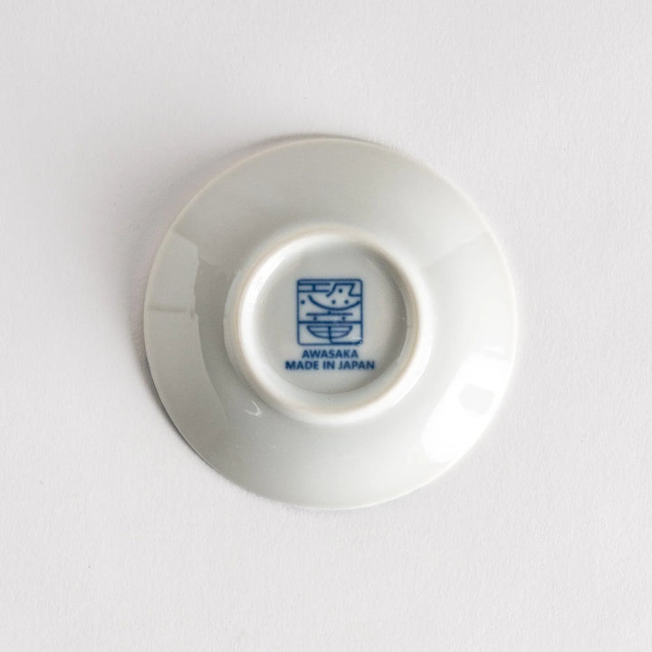 Set of four Japanese porcelain plates in gift box each with blue and red dinosaur design decoration.