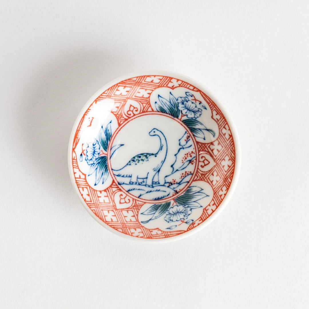 Set of four Japanese porcelain plates in gift box each with blue and red dinosaur design decoration.