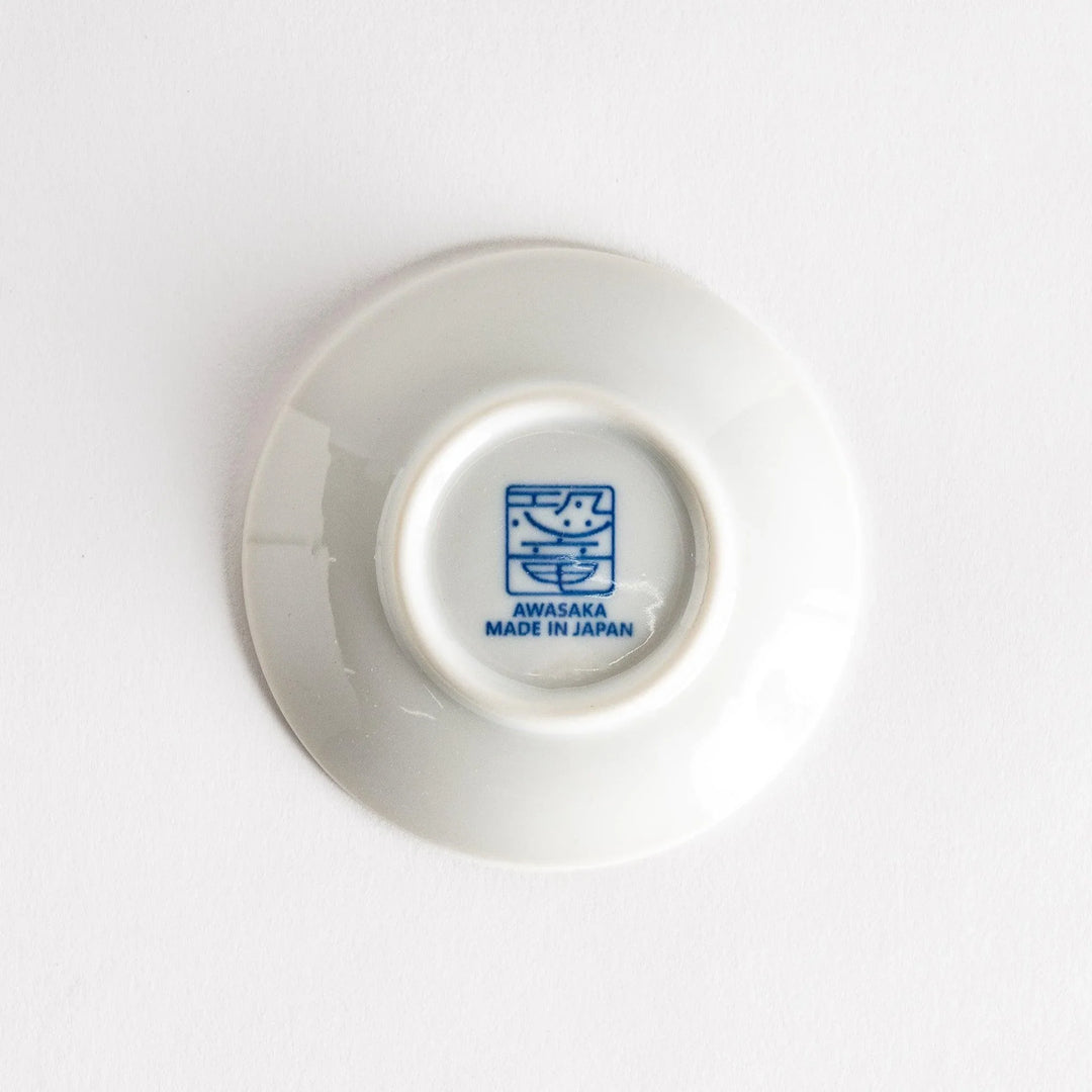 Set of four Japanese porcelain plates in gift box each with blue and red dinosaur design decoration.