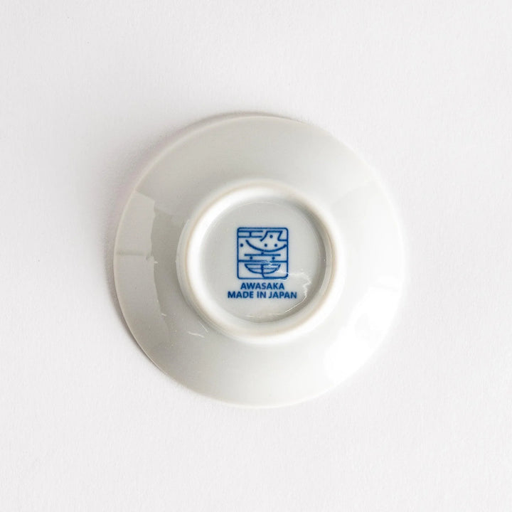 Set of four Japanese porcelain plates in gift box each with blue and red dinosaur design decoration.