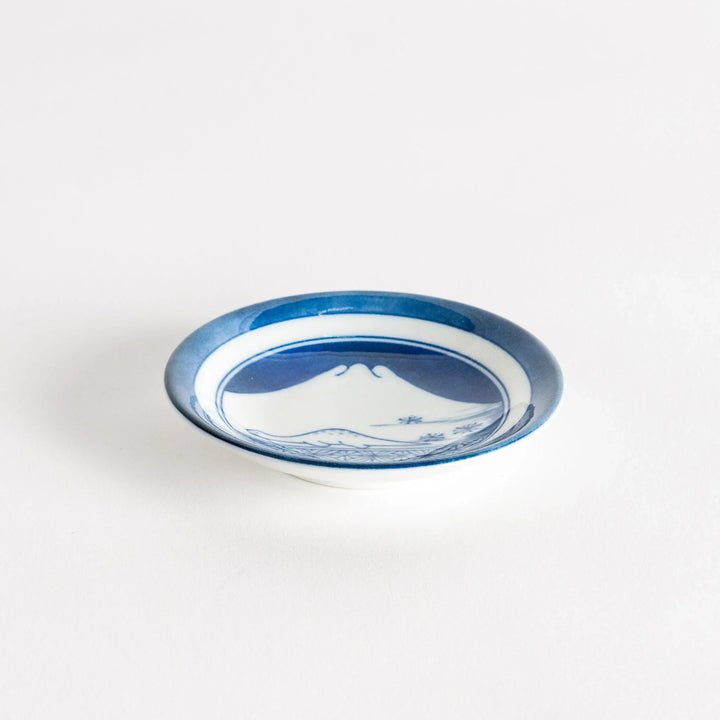 Set of four Japanese porcelain plates in gift box each with blue and red dinosaur design decoration.