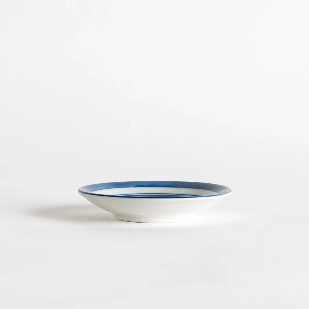 Set of four Japanese porcelain plates in gift box each with blue and red dinosaur design decoration.