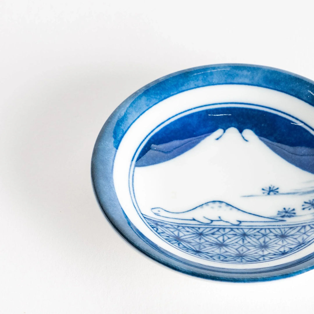Set of four Japanese porcelain plates in gift box each with blue and red dinosaur design decoration.