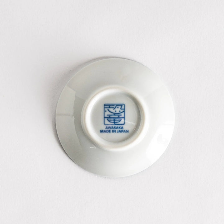 Set of four Japanese porcelain plates in gift box each with blue and red dinosaur design decoration.