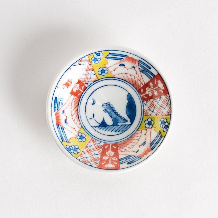 Set of four Japanese porcelain plates in gift box each with blue and red dinosaur design decoration.