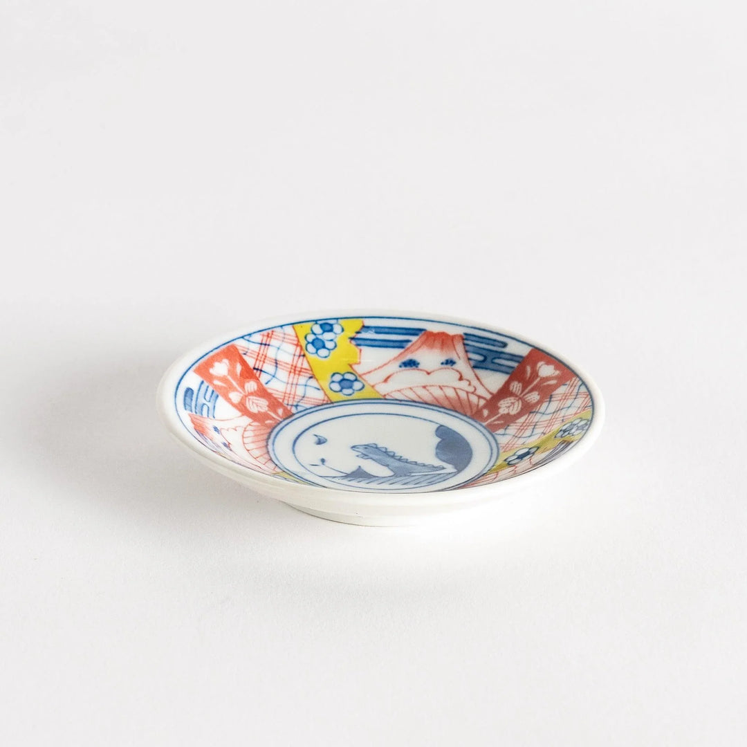 Set of four Japanese porcelain plates in gift box each with blue and red dinosaur design decoration.