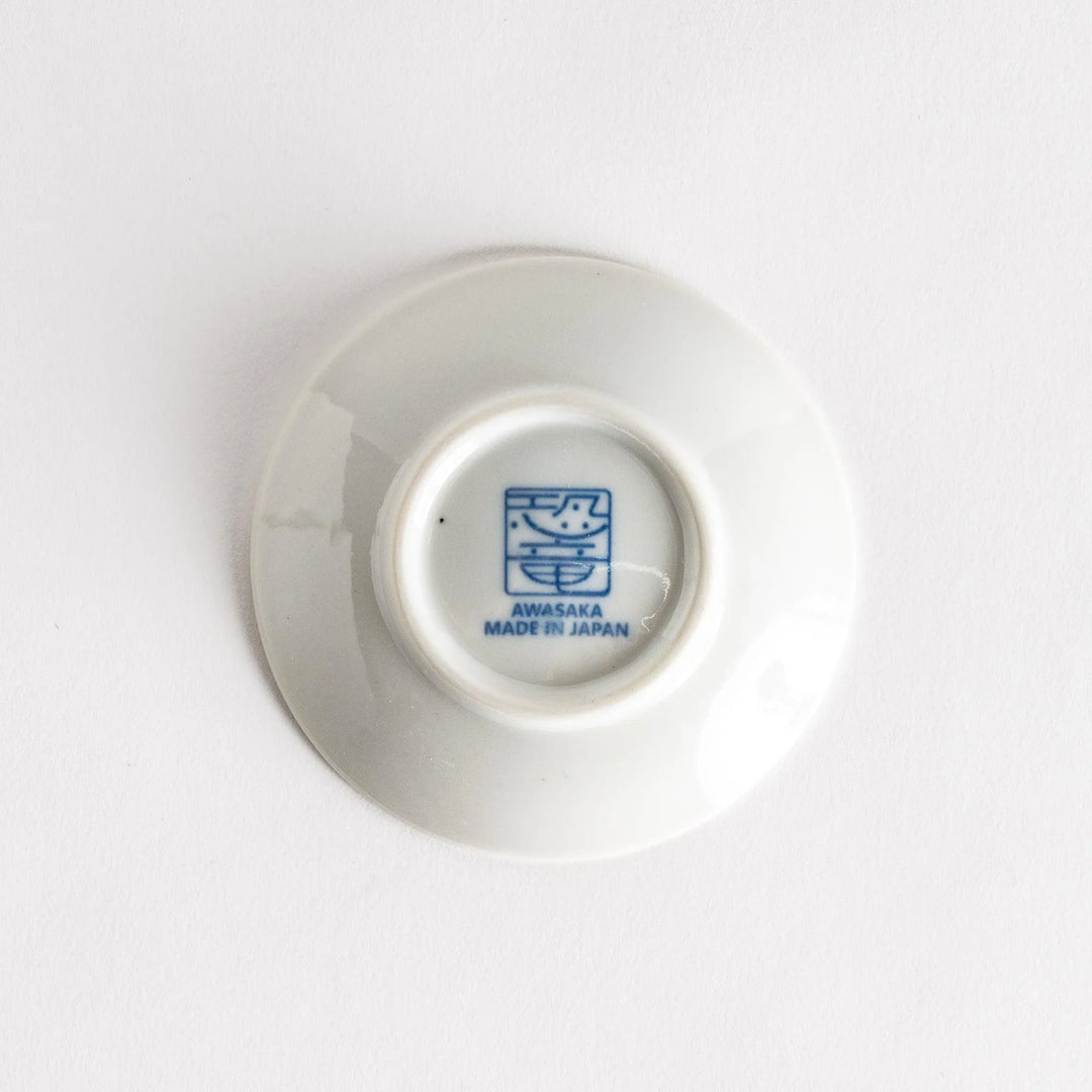 Set of four Japanese porcelain plates in gift box each with blue and red dinosaur design decoration.