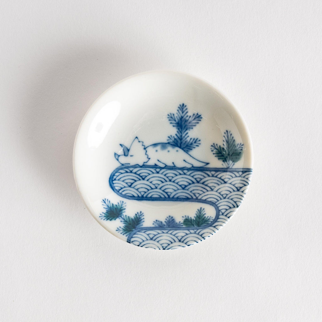 Set of four Japanese porcelain plates in gift box each with blue and red dinosaur design decoration.