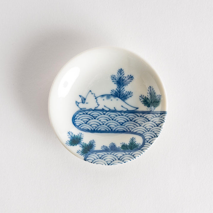 Set of four Japanese porcelain plates in gift box each with blue and red dinosaur design decoration.