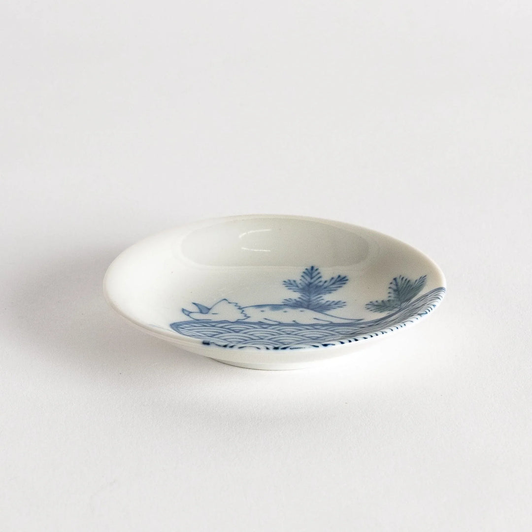 Set of four Japanese porcelain plates in gift box each with blue and red dinosaur design decoration.