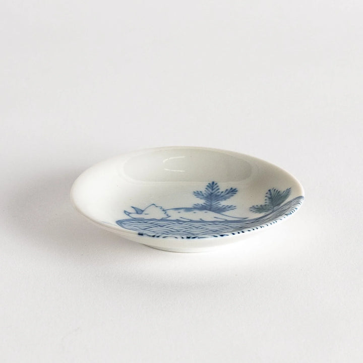 Set of four Japanese porcelain plates in gift box each with blue and red dinosaur design decoration.