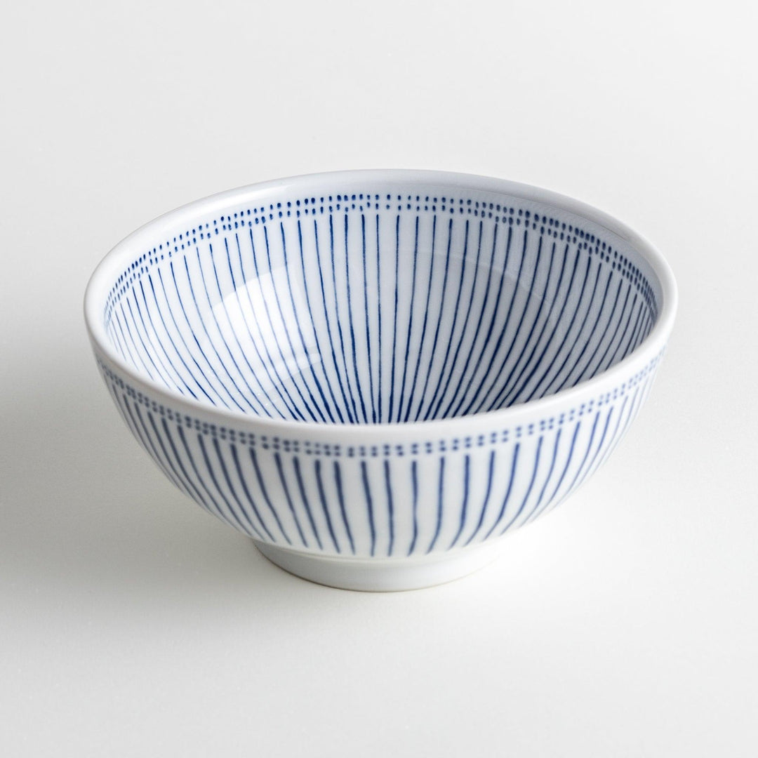 A white porcelain bowl with thin blue vertical stripes and dotted patterns around the rim.