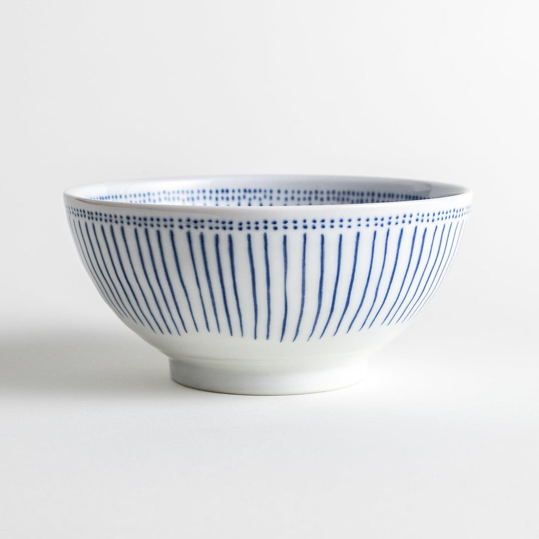 A white porcelain bowl with thin blue vertical stripes and dotted patterns around the rim.