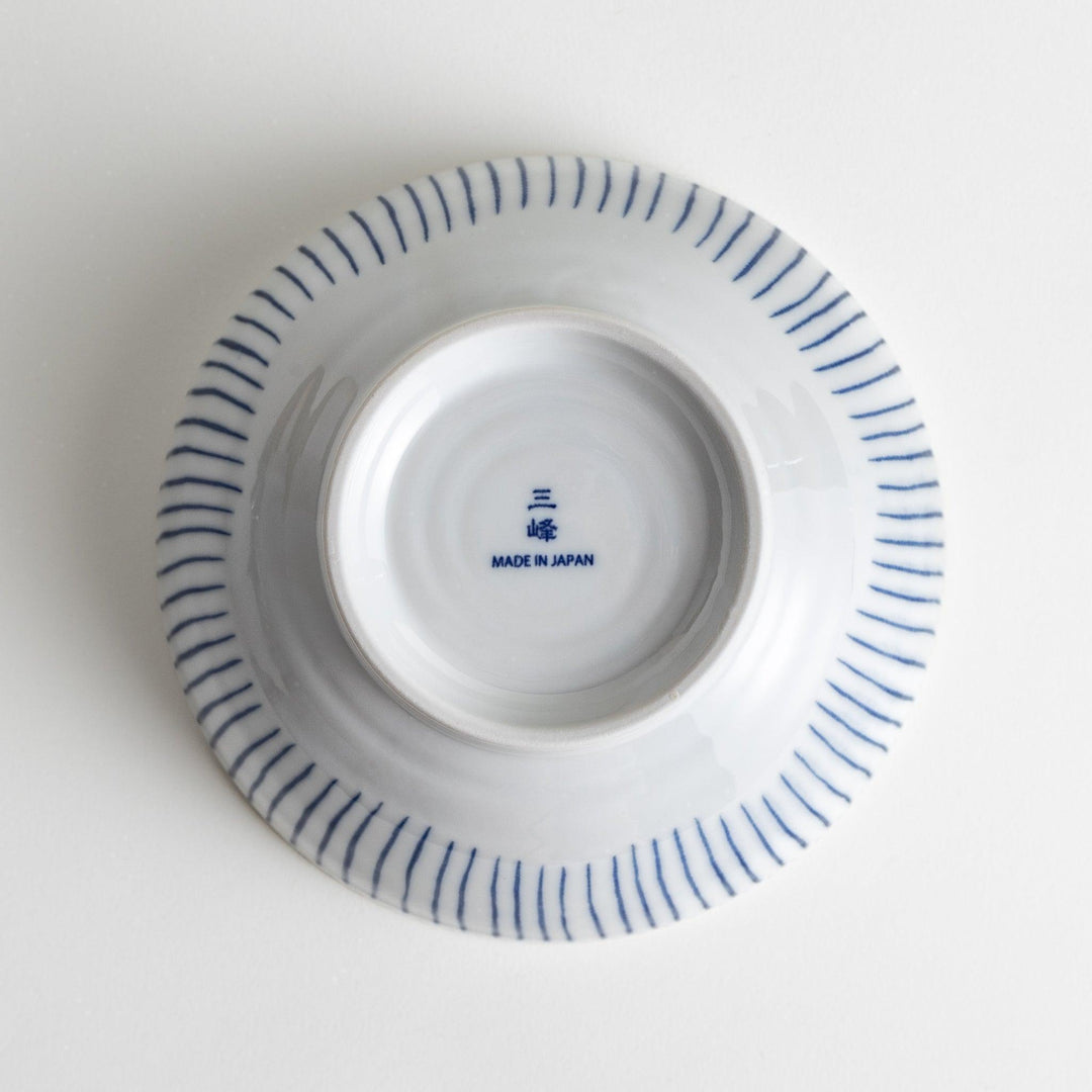 A white porcelain bowl with thin blue vertical stripes and dotted patterns around the rim.