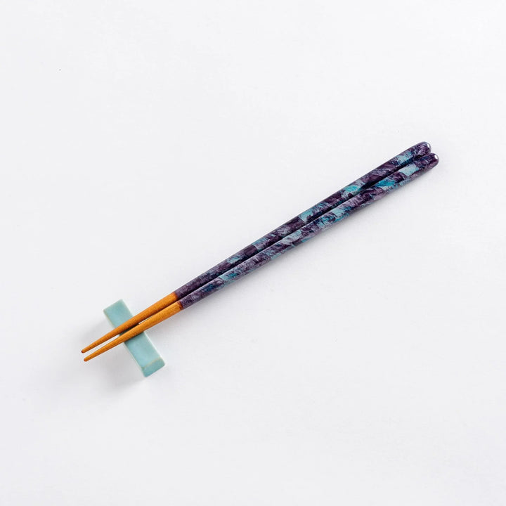 Close-up of the textured upper part of the dark blue chopsticks, showing intricate patterns.