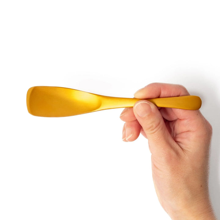 Gold aluminum ice cream spoon with matte finish and flat scoop edge designed to glide through hard ice cream.