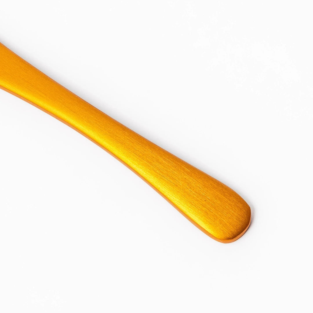 Gold aluminum ice cream spoon with matte finish and flat scoop edge designed to glide through hard ice cream.