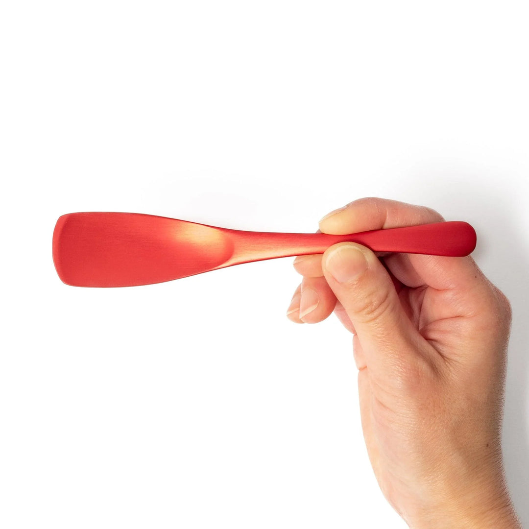 Red aluminum ice cream spoon with a flat edge and matte finish, designed to cut through hard ice cream with ease and comfort.