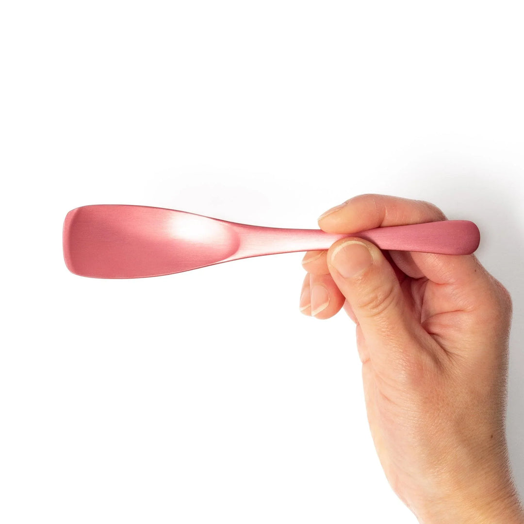 Pink aluminum ice cream spoon with ergonomic curve and matte finish, perfect for effortlessly scooping hard ice cream.