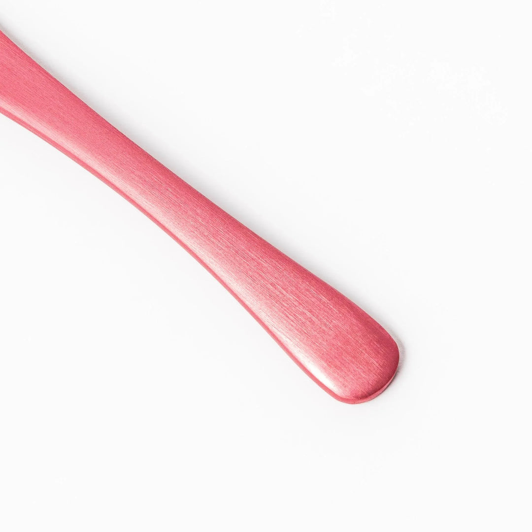 Pink aluminum ice cream spoon with ergonomic curve and matte finish, perfect for effortlessly scooping hard ice cream.