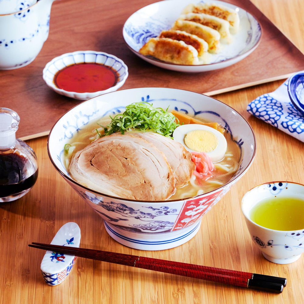 A Japanese ramen bowl featuring a charming dinosaur illustration in a traditional Imari-style design, filled with miso ramen.