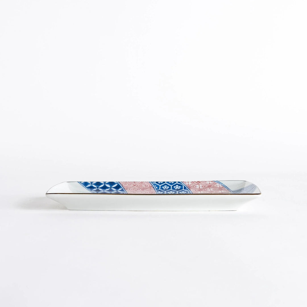 Side view of the rectangular dessert plate, showcasing the unique shape and colorful design with a dinosaur motif.