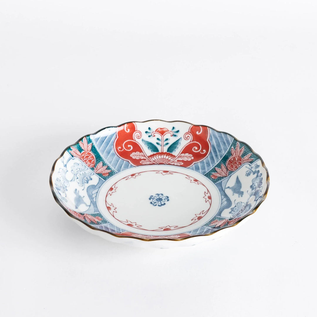 Side view of the decorative plate, highlighting its scalloped edges and colorful floral patterns.