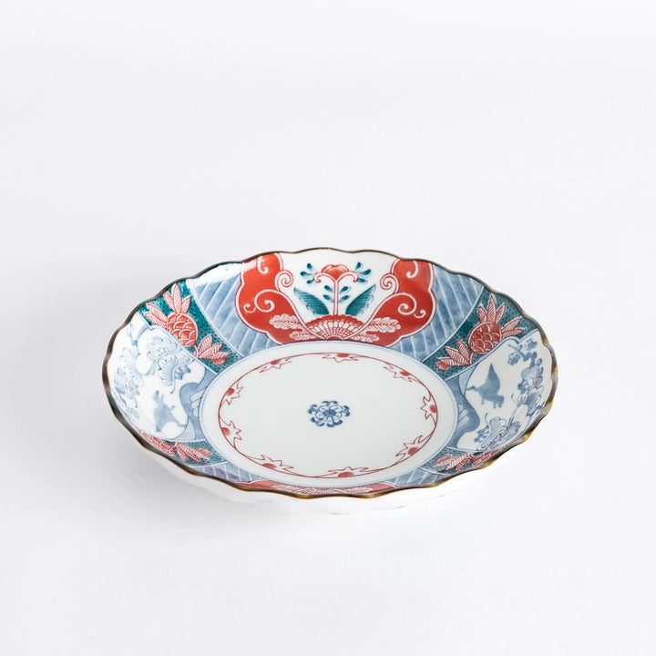 Side view of the decorative plate, highlighting its scalloped edges and colorful floral patterns.