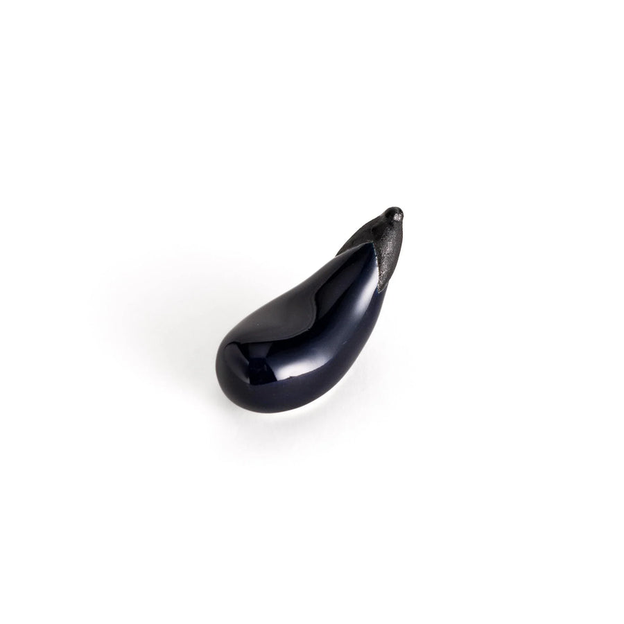 Glossy purple ceramic eggplant chopstick rest with black stem adding unique charm to Japanese table setting.