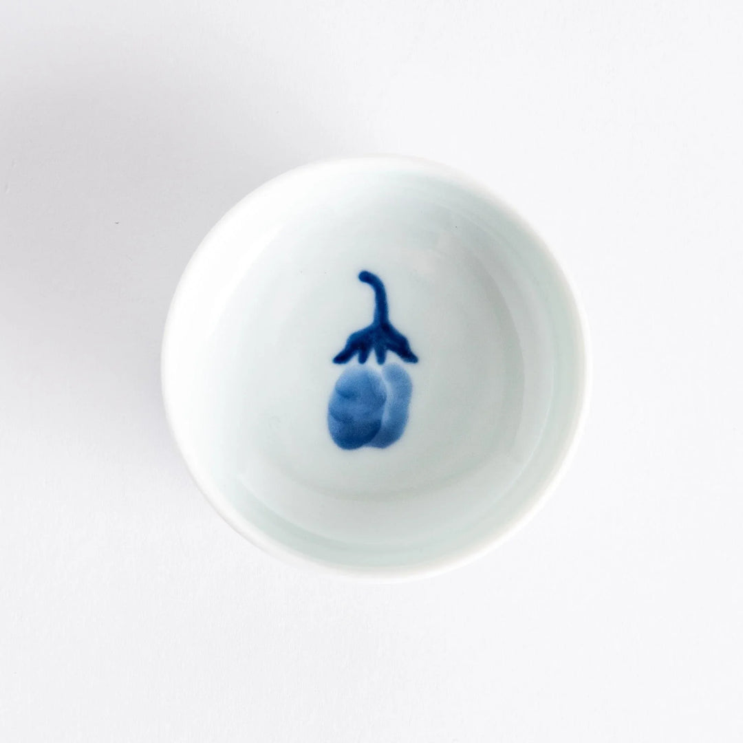 Small raised Japanese sauce dish with blue eggplant design inside and vertical blue lines along the edge.