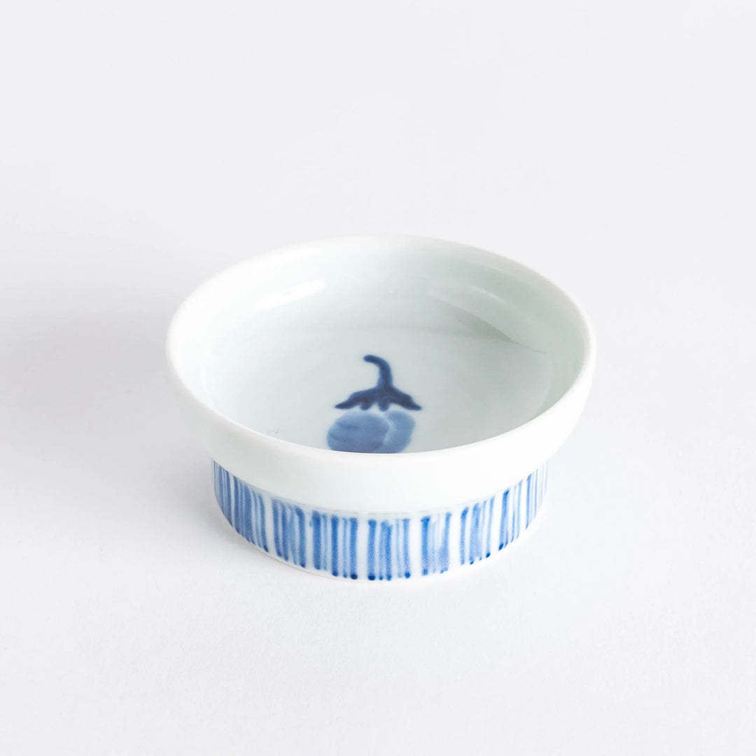 Small raised Japanese sauce dish with blue eggplant design inside and vertical blue lines along the edge.