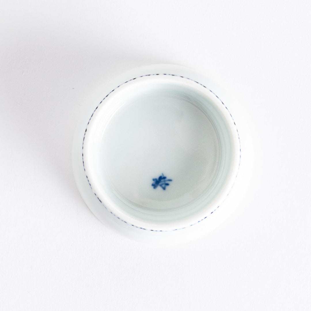Small raised Japanese sauce dish with blue eggplant design inside and vertical blue lines along the edge.