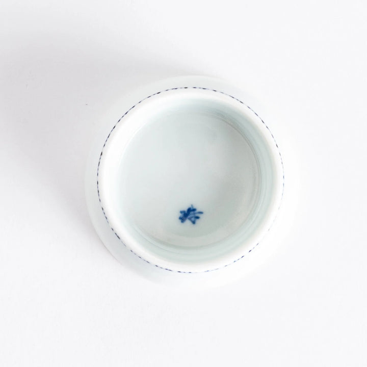 Small raised Japanese sauce dish with blue eggplant design inside and vertical blue lines along the edge.