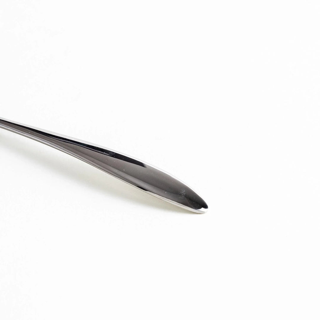 Close-up of a stainless steel spoon's handle, highlighting its sleek, smooth design.