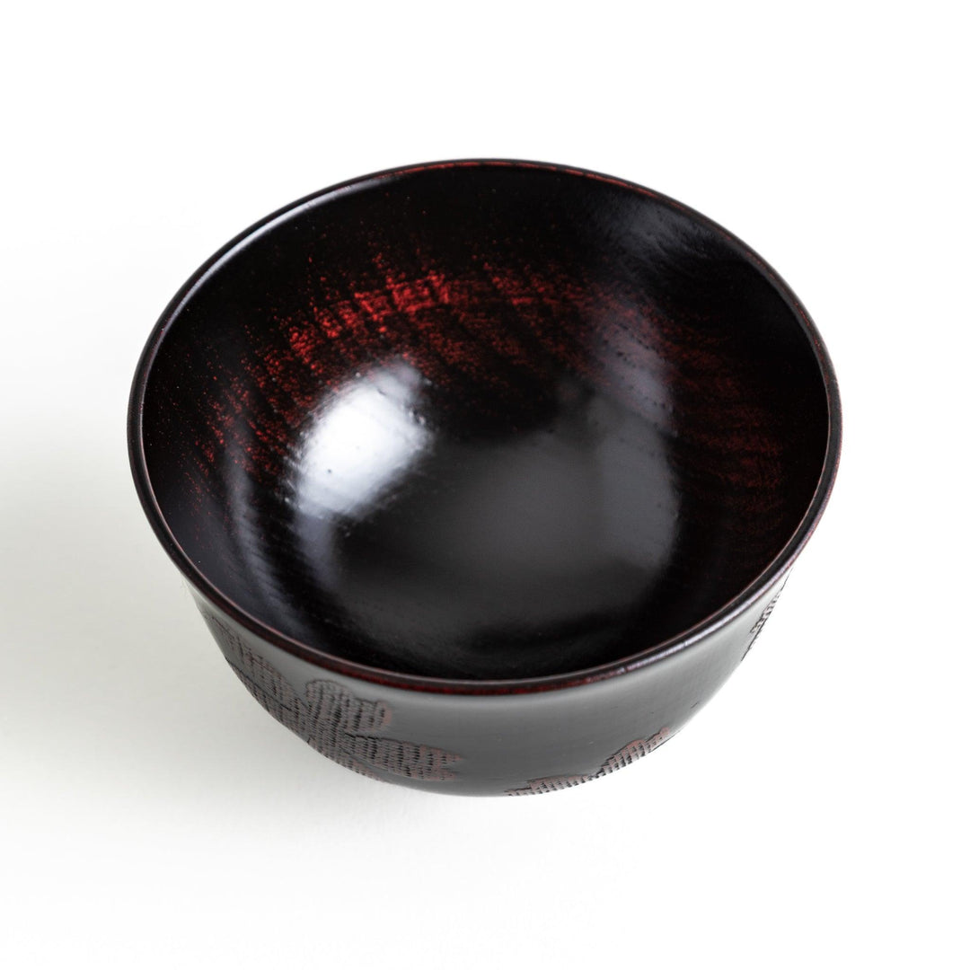 A lacquered bowl featuring a textured black floral design and a smooth, polished finish. Available in black or red.