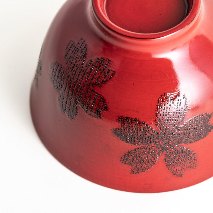 A lacquered bowl featuring a textured black floral design and a smooth, polished finish. Available in black or red.