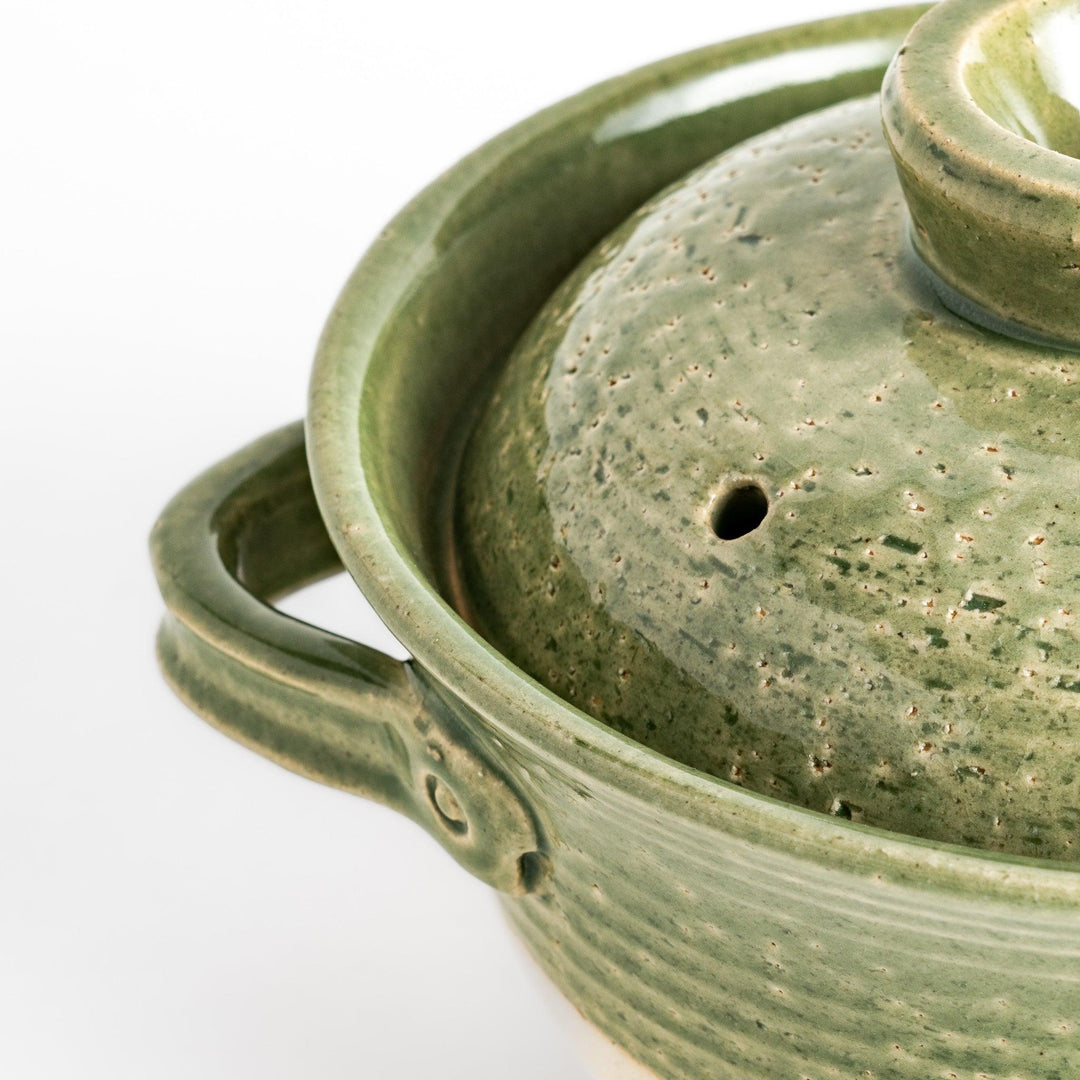 Emerald rice donabe clay pot with green glaze and round lid ideal for cooking flavorful Japanese rice.