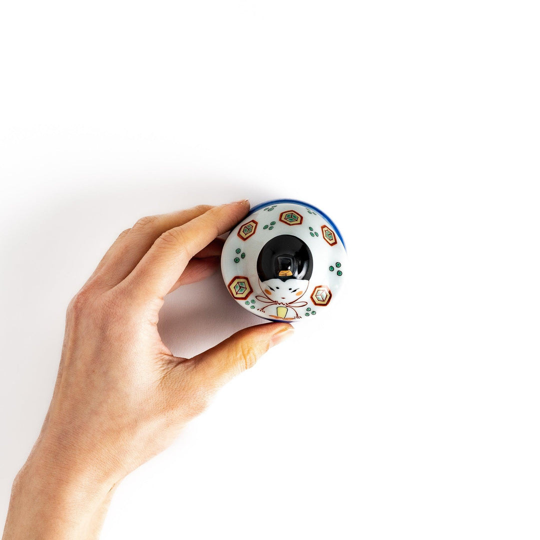 Ceramic condiment bowl with Japanese doll design perfect for serving sauces spices or small snacks.