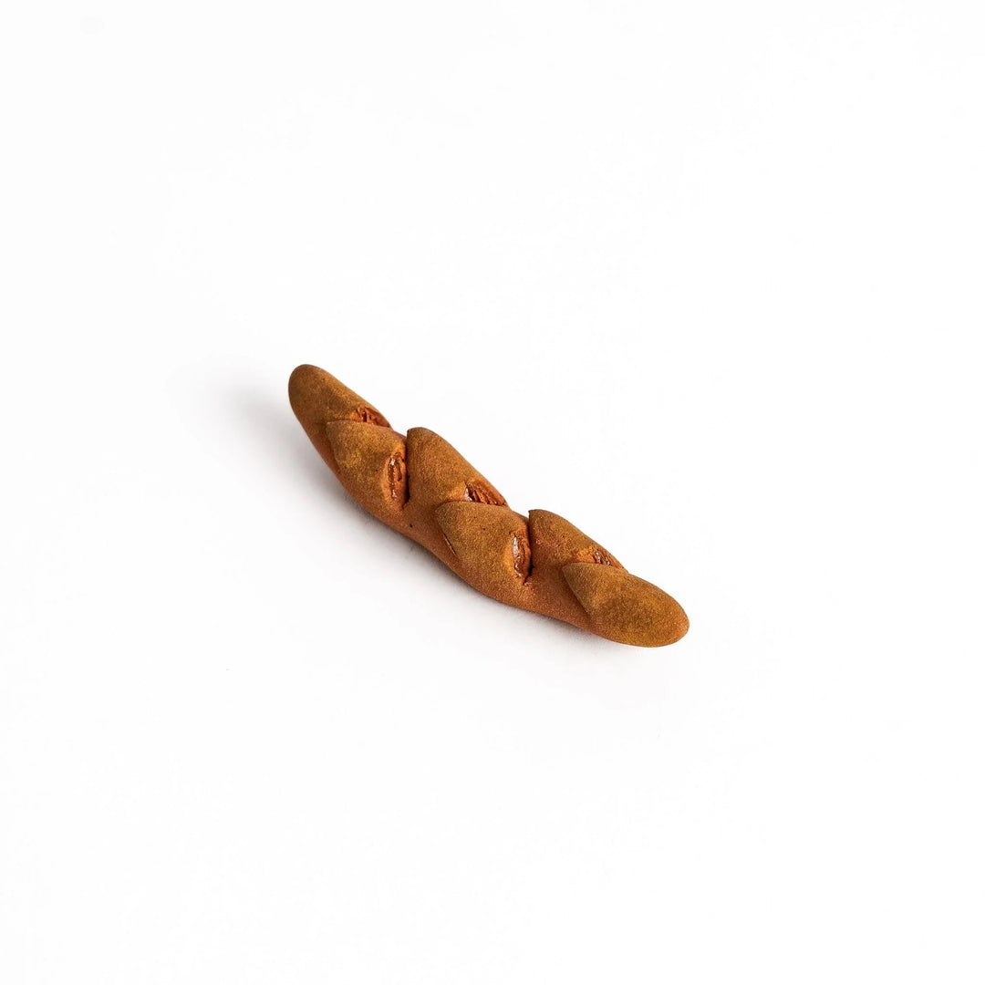 Epi bread shaped chopstick rest with warm brown glaze and detailed texture bringing bakery charm.